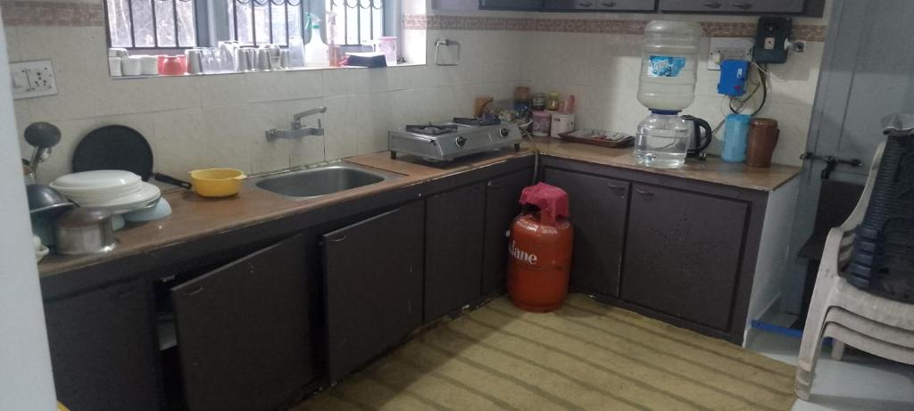 Il comprend une cuisine équipée d'un évier. un extincteur dans l'établissement December Holiday inn 2BHK House, à Kodaikānāl