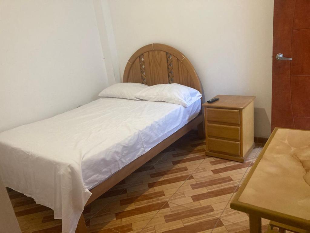 a small bedroom with a bed and a night stand at Starfish in Paracas