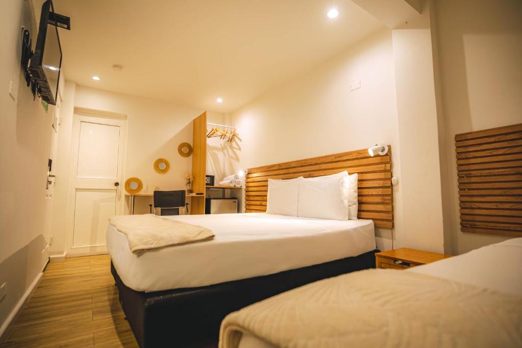a hotel room with two beds and a desk at Ataraxy Hotel Boutique in San Andrés