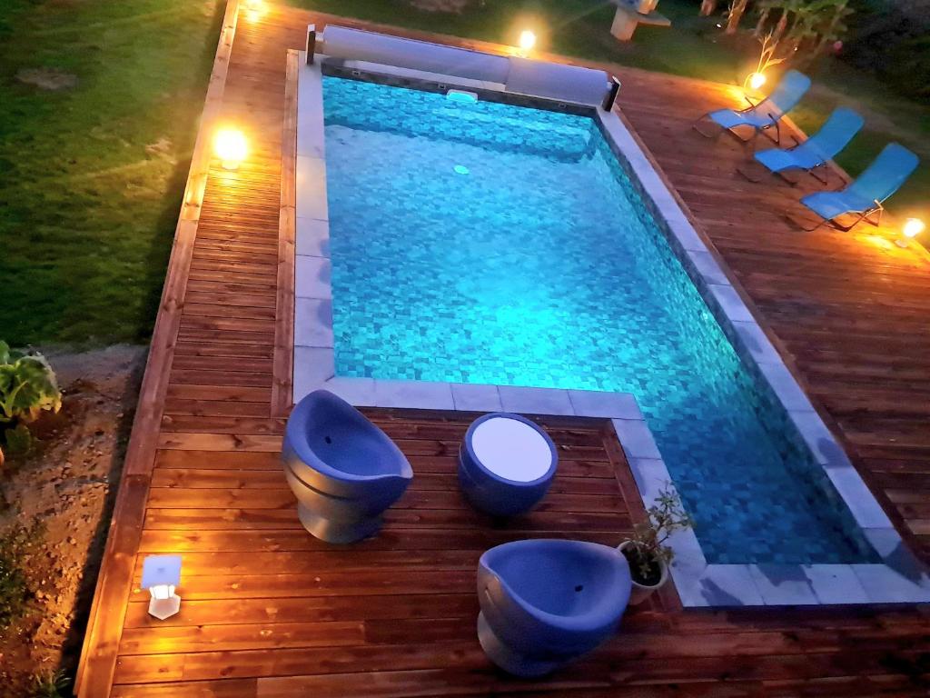 uma piscina com banheiros azuis em um deck de madeira em gîte en campagne Lamégritnière em Mégrit