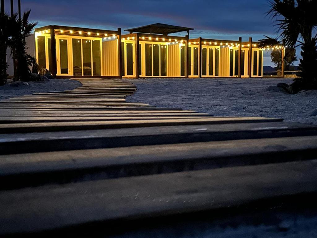 a row of yellow buildings with lights on them at Wine Hotel Punta Arena in Bahía de los Ángeles