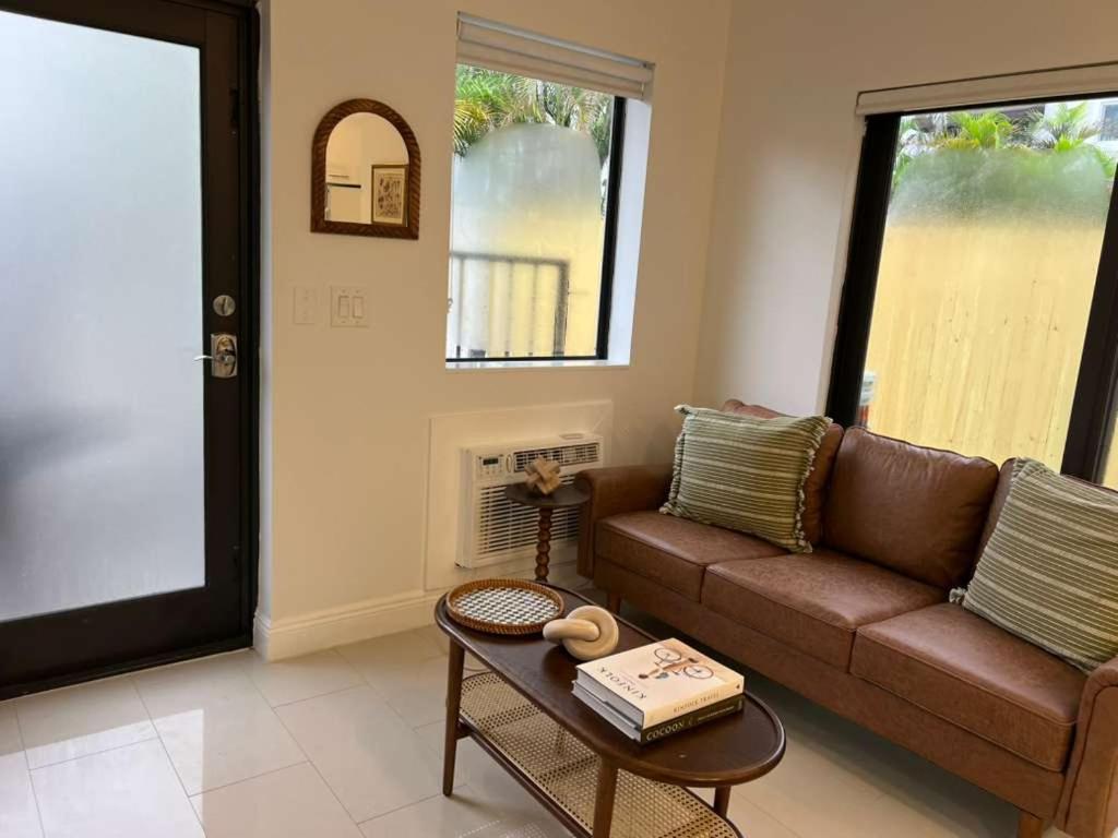 a living room with a brown couch and a table at Chic Modern Studio with Queen Bed in Fort Lauderdale