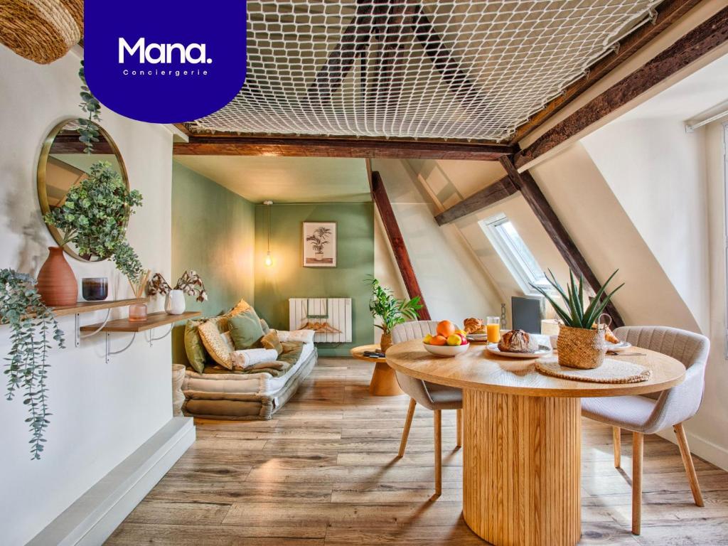 a kitchen and living room with a table in a room at Le Criquet - Hypercentre - Filet de détente in Caen