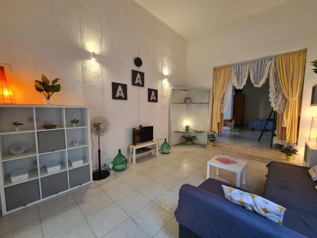 ナルドにあるSalento - Casa Vacanza di appartamento open spaceの青いソファとテレビのあるリビングルーム