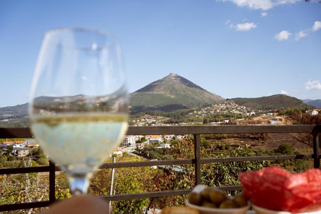 un verre de vin avec vue sur une montagne dans l'établissement Casa da Estação, vista rio Tâmega e Senhora da Graça, à Veade