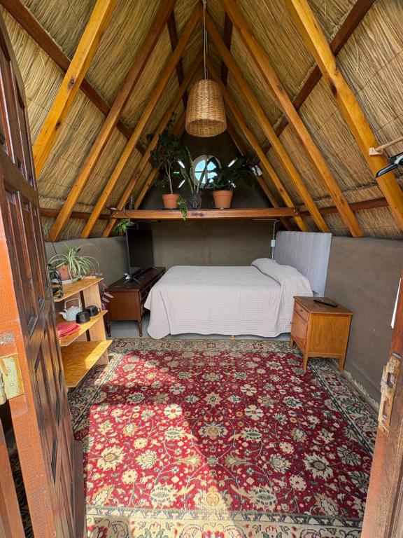 a bedroom with a bed and a rug in a attic at Kuttir Le Dome in Quequén