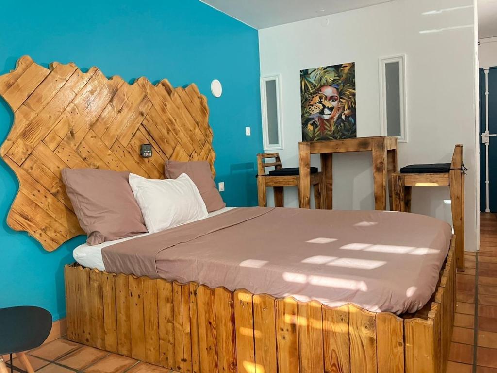 a bedroom with a wooden bed with a wooden headboard at Cosy Studio in La Trinité