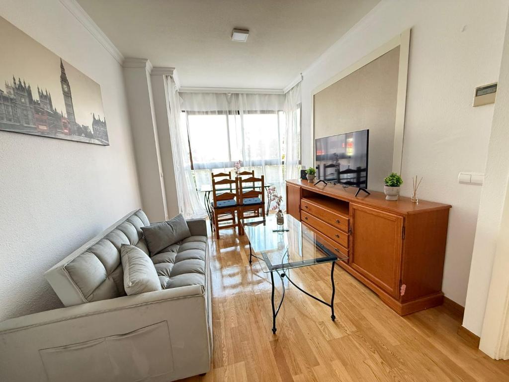 een woonkamer met een bank, een tv en een tafel bij Happy holidays Madrid in Madrid