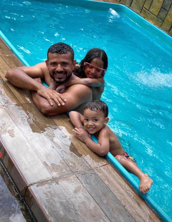 un hombre, una mujer y un niño en una piscina en Casa Borges, en Aparecida de Goiania