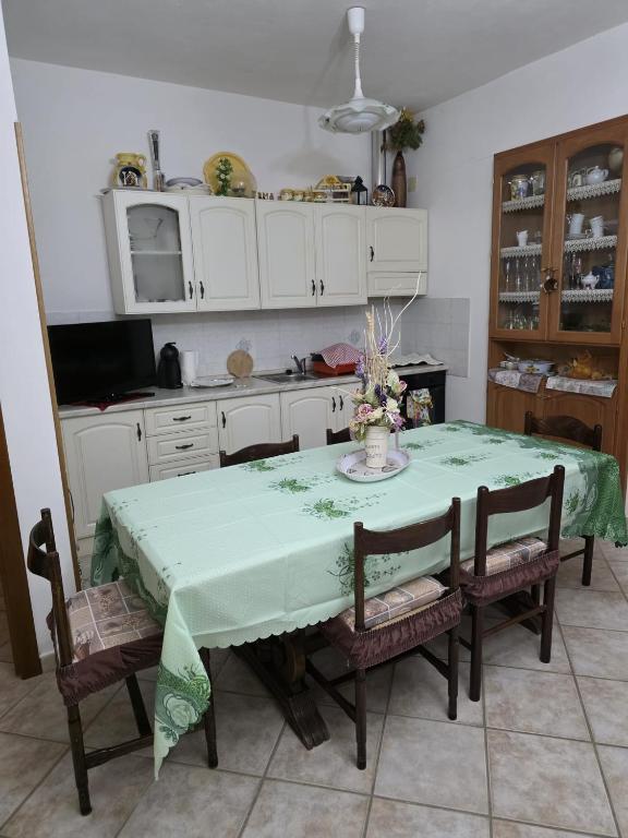 cocina con mesa y mantel verde en Lucia's House, en Iglesias