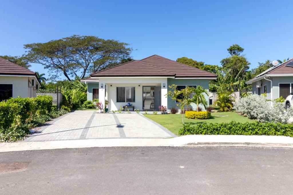 a house with a driveway in front of it at Three Bedroom Villas in Drax Hall - Pool Gym - 24hr Security - Beach Closely in Saint Annʼs Bay
