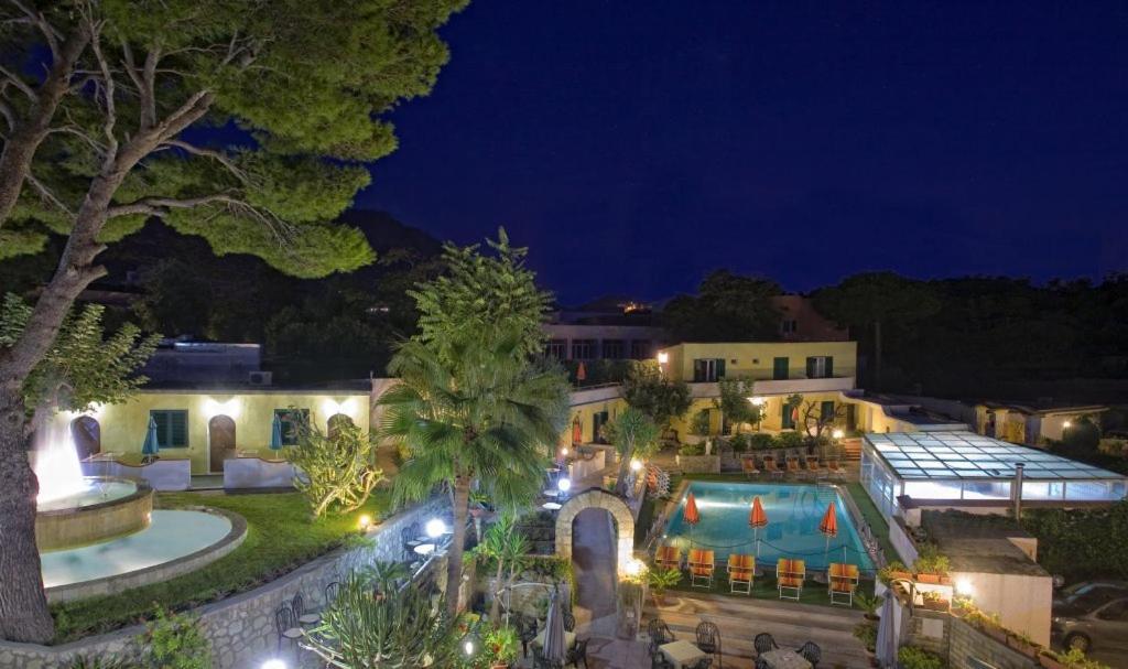 eine Luftansicht eines Hauses mit Pool in der Nacht in der Unterkunft Albergo Villa Hibiscus in Ischia