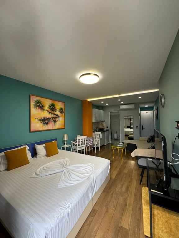 ein Schlafzimmer mit großem Bett und ein Wohnzimmer in der Unterkunft Your Cozy Stay - Tirana in Tirana