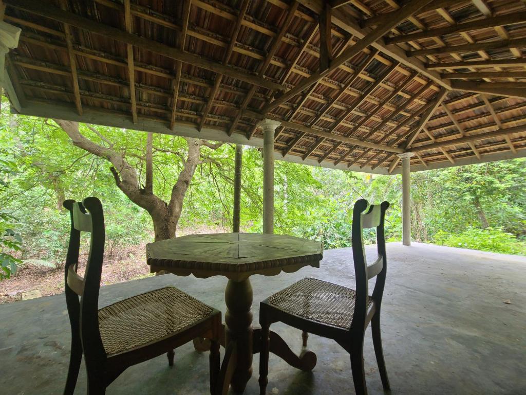 una mesa y dos sillas en un porche en CalmDown, en Ahangama