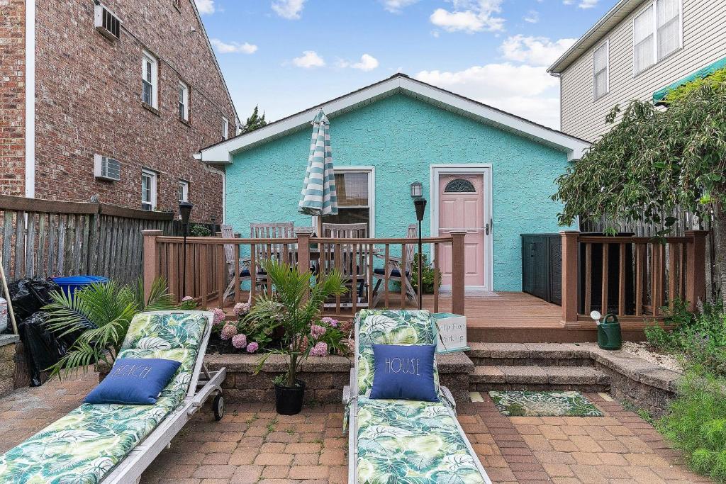 a patio with two chairs and a blue house at Margate Home w/ Large Outdoor Kitchen in Margate City