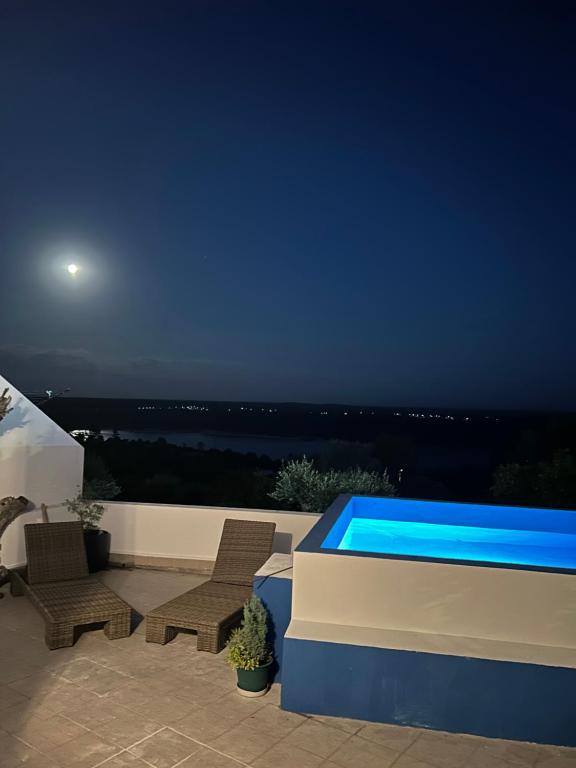 a patio with a swimming pool at night at Casa Lusa Montargil in Montargil