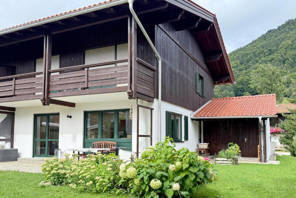 a house with a balcony and a table at FeWo Zuhause Ruhpolding in Ruhpolding