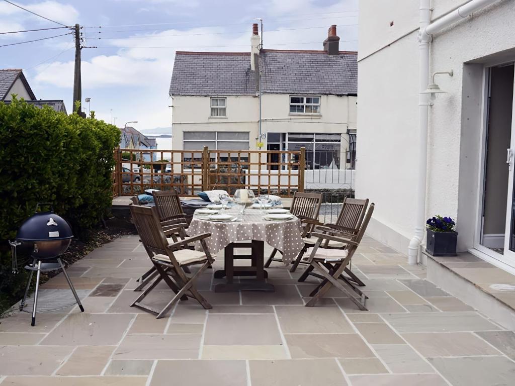 a patio with a table and chairs on a balcony at West View in Rhosneigr