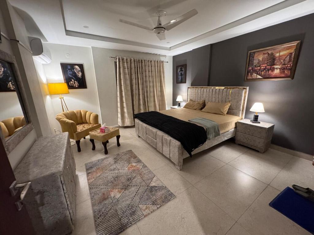 a bedroom with a bed and a couch and a chair at JW Apartments in Dargai