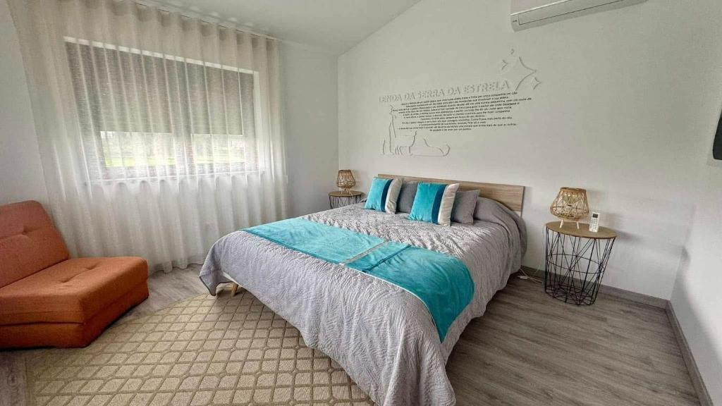 een slaapkamer met een bed, een stoel en een raam bij Matias Nature - Mountain Lodges in Serra da Estrela, Seia in Carragozela