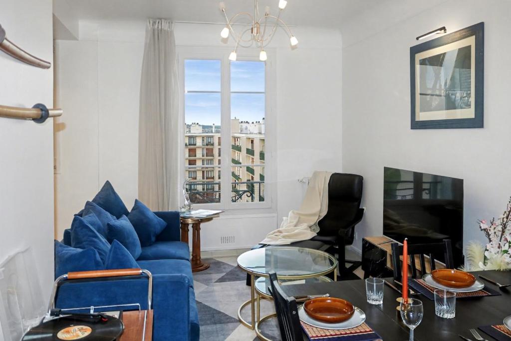 a living room with a blue couch and a table at Urban Lux Colombes in Colombes