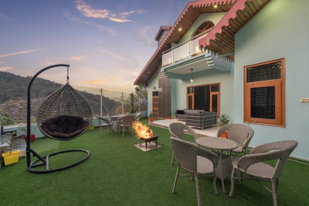 um pátio com cadeiras, uma rede de descanso e uma lareira em The Corner House I Pet friendly & Serviced Villa I Open Air Lawn & Plunge Pool I Bonfire I Dance I Music I Full Party I Kasauli By Exotic Stays em Kasauli