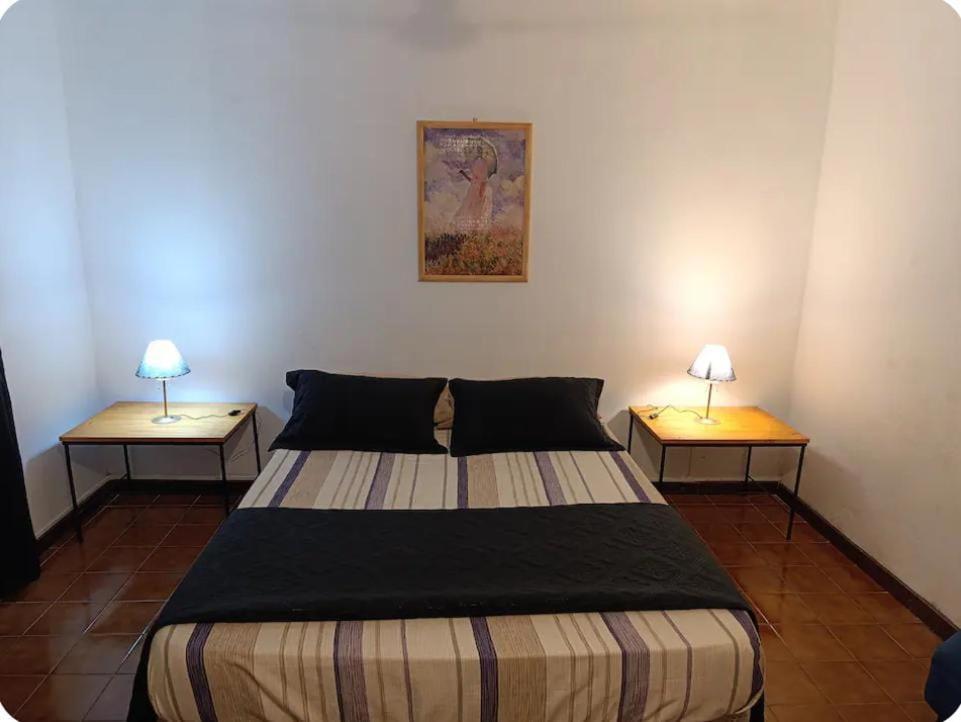 ein Schlafzimmer mit einem Bett und zwei Lampen an zwei Tischen in der Unterkunft Departamento Céntrico con Estacionamiento in Oberá