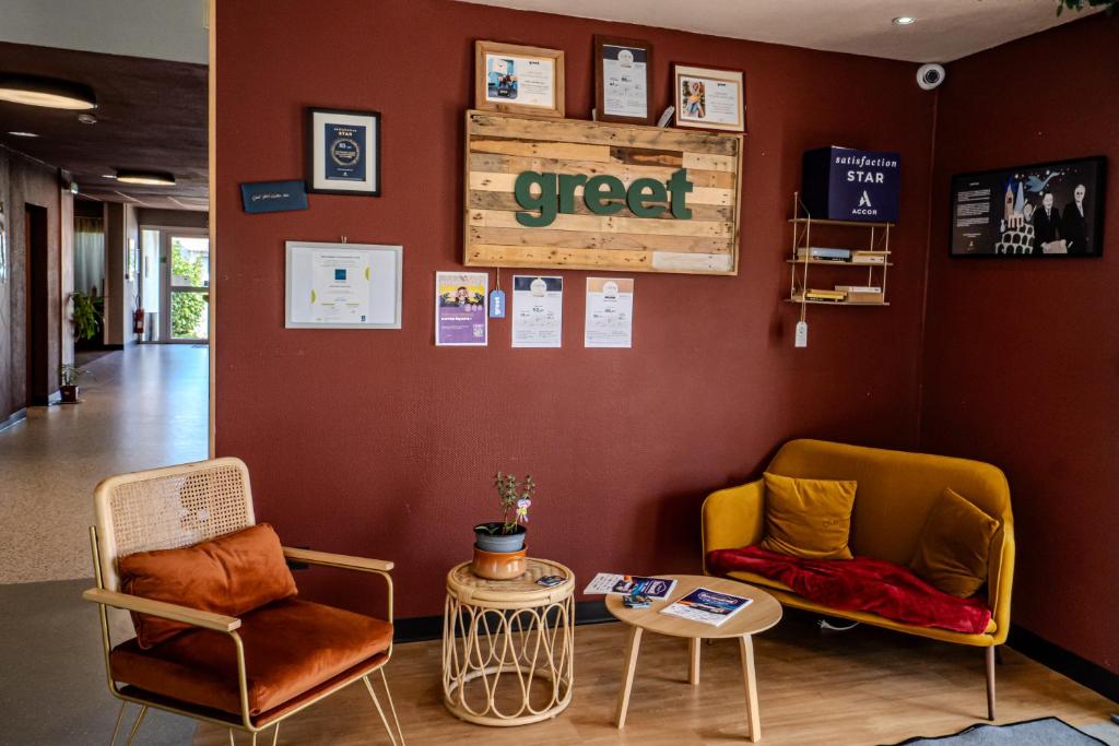 una sala de espera con dos sillas y una mesa en Greet Hôtel Castres Saix, en Saix