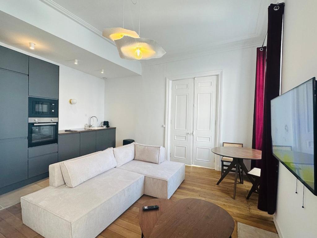 a living room with a white couch and a table at Hyper Centre Cathédrale Boulingrin 101 in Reims