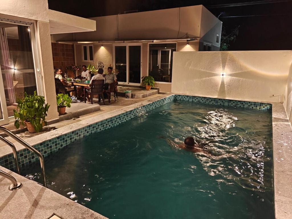 a person swimming in a swimming pool at Maple Dreams Retreat- A Pool side Villa in Pondicherry