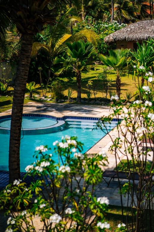 a swimming pool in a resort with palm trees at Vila Saguaro in Flecheiras