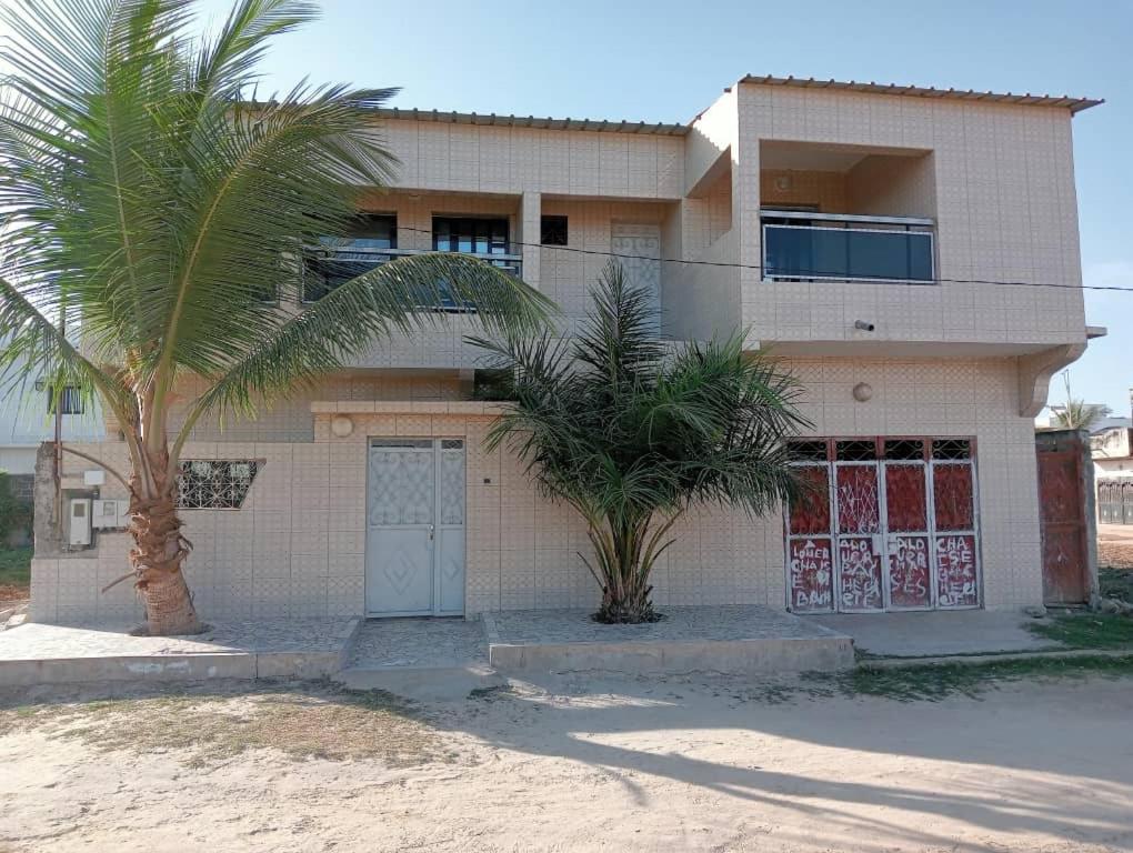 una casa con dos palmeras delante de ella en Keur Vieux DIATTA, en Ziguinchor