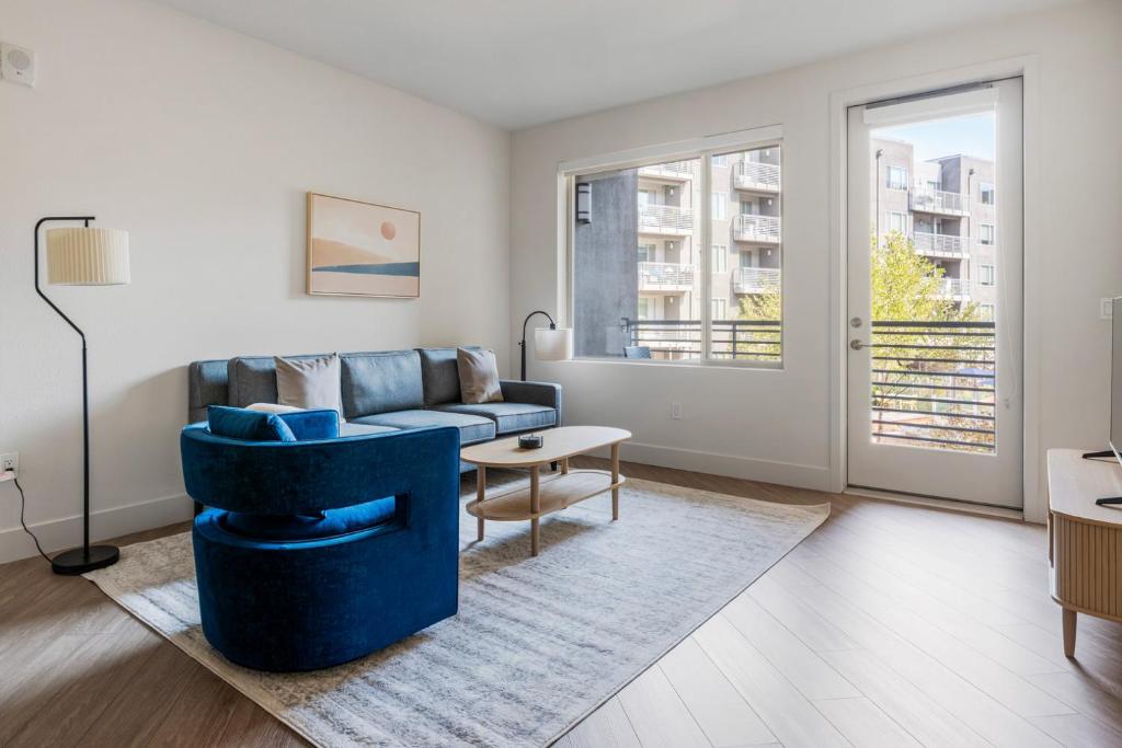 Una sala de estar con un sofá azul y una mesa. en Blueground East Industrial pool nr Lake Elizabeth SFO-2000, en Warm Springs District