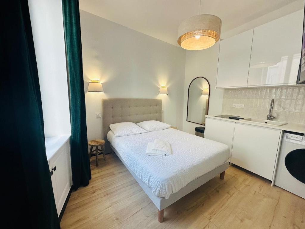 a white bedroom with a bed and a kitchen at Hyper Centre Cathédrale Boulingrin 102 in Reims