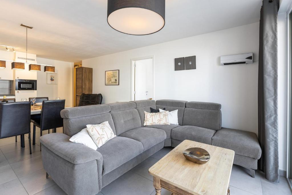 a living room with a couch and a table at Plaza in Sint-Idesbald