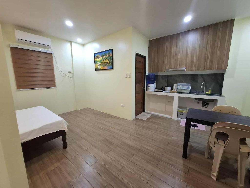 a living room with a table and a kitchen at Carolina Siargao Homestay in General Luna