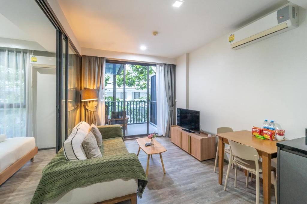 a living room with a bed and a table at Elegant 1BR Garden-View Condo - The Deck Patong in Patong Beach
