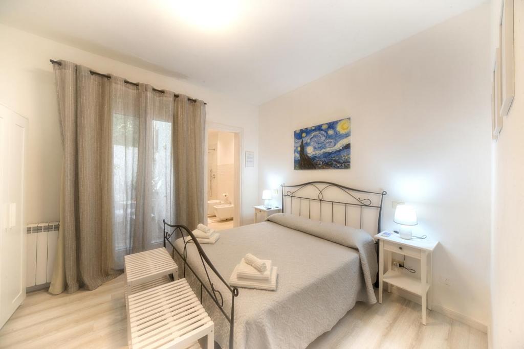 Un dormitorio blanco con una cama y una ventana. en Margherita Guest House, en Olbia