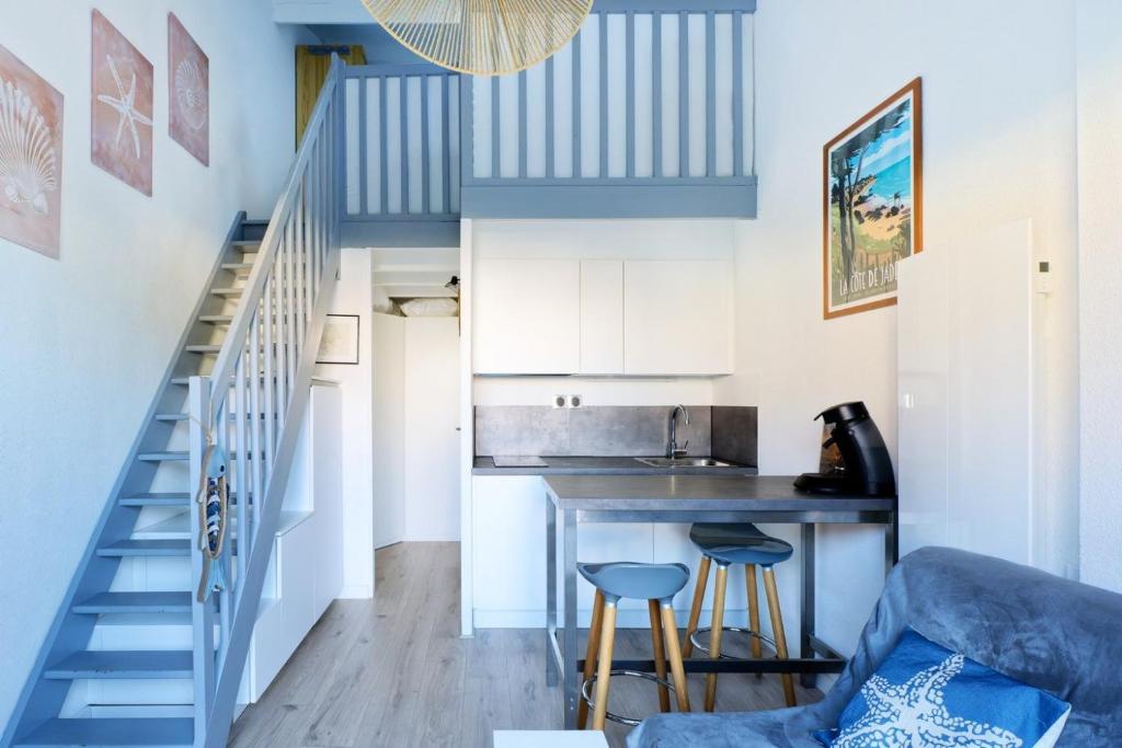 a small kitchen with blue and white walls and a staircase at Maisonnette des Poissons, à 50 m de la mer in Pornic