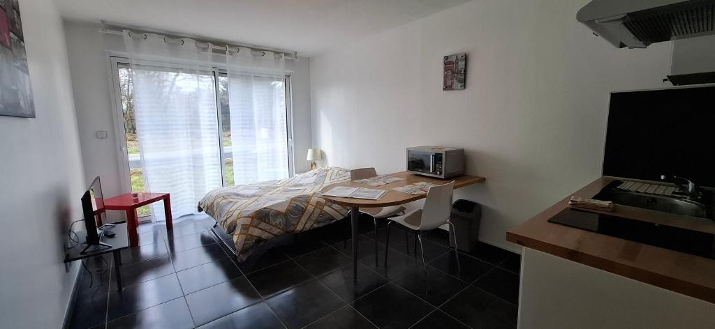 a bedroom with a bed and a table with a microwave at Dampierre Studio 300 m du CNPE in Dampierre-en-Burly