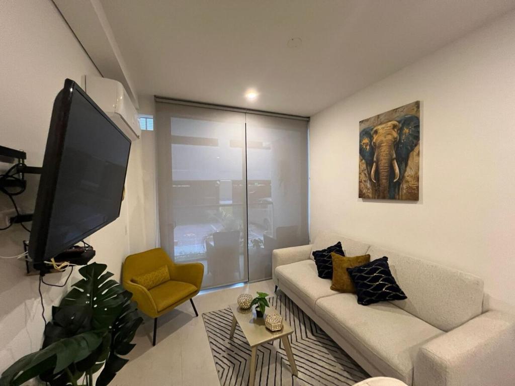 a living room with a couch and a flat screen tv at Apartamento en Salinas Del Mar, a 10 min de la playa in Gaira