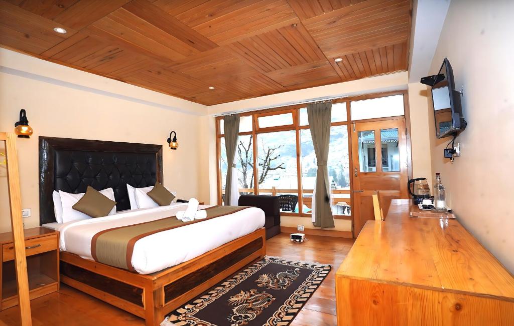 a bedroom with a large bed and a wooden ceiling at The Country House by Trekocity in Lachung