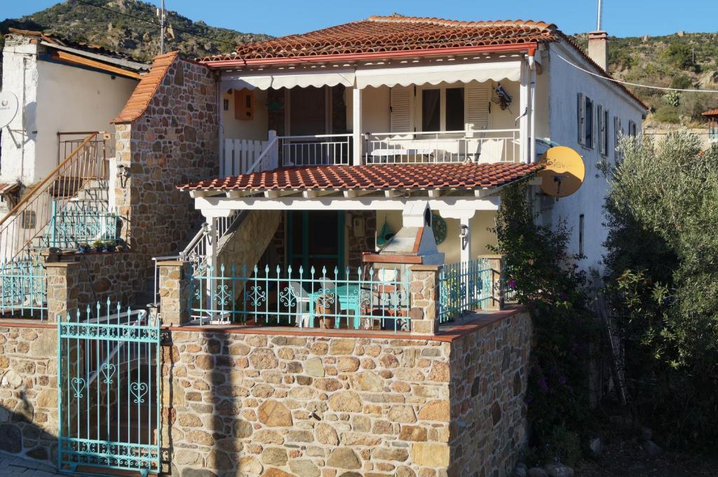 une maison en briques avec un balcon sur le toit dans l'établissement House Eleni, à Sikia