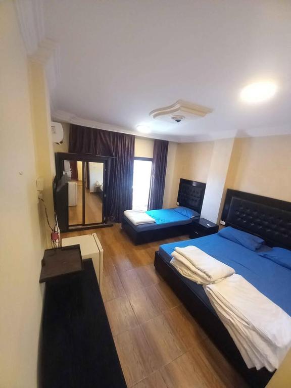 a large room with two beds and a window at فندق برستيج العقبه Prestig in Aqaba