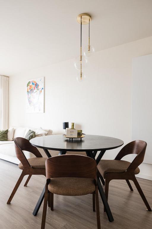 奥斯坦德Let's Go Getaways - Raversijde的配有黑色桌子和椅子的餐厅