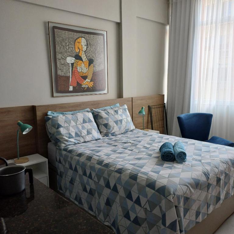 Hotel Charme da Santa Clara, antigo Copa Alegria, a bedroom with a bed with blue shoes on it at Charme da Santa Clara, antigo Copa Alegria in Rio de Janeiro