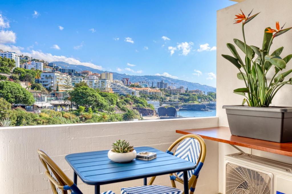 a blue table and chairs on a balcony with a view at Aida's Place, a Home in Madeira in Ilhéu do Gorgulho