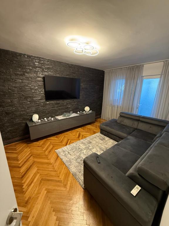 Una sala de estar con un sofá y un televisor de pantalla plana. en Apartamentul lui Radu, en Caracal