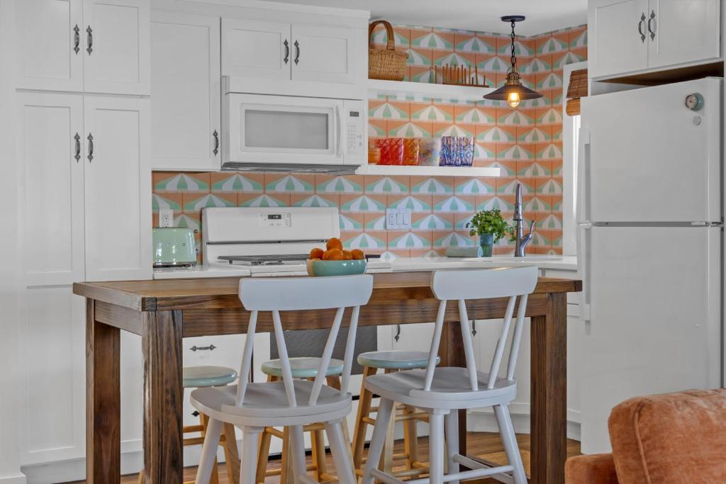 a kitchen with white cabinets and a wooden table with stools at Hot Tub 3BR Lavallette Girls Trip at the Beach in Monterey Beach
