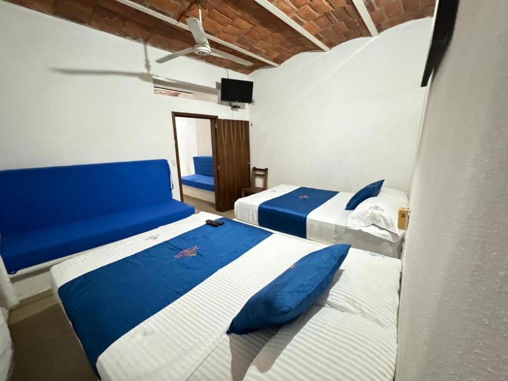 deux lits dans une chambre avec du bleu et du blanc dans l'établissement Hotel y Bungalows Resort, à Los Ayala